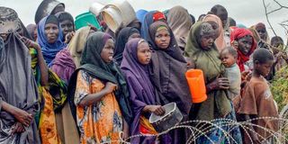 Internally-displaced Somalis wait for food at a distribution point in Mogadishu.