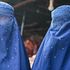 An Afghan vendor displays a burqa at his shop