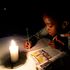 A Zimbabwean boy does his homework using a candle. 
