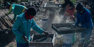 Independent miners filter dirt and soil as they search for minerals following the legalisation of mining in limited areas 