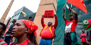 A man holds a sign saying that Eskom, the South African electricity public utility, is not for sale 