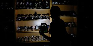 A woman uses a rechargeable LED lantern to illuminate a shoe rack while shopping at the Sinnoville Centre
