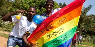 Ugandan men hold a rainbow flag