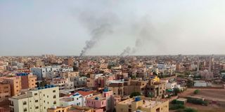 Smoke billows behind buildings in Khartoum