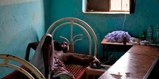 An injured Sudanese man lies on a bed in Khartoum's twin city Omdourman